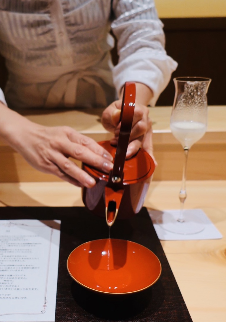 朱の片口から盃へ、お酒を注ぐ